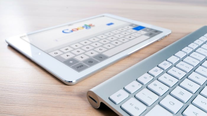 Tablette posée sur un bureau ouverte sur l'écran d'accueil de Google