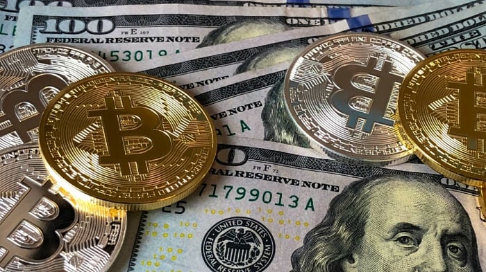 Tas de billets et de pièces avec le symbole Bitcoin