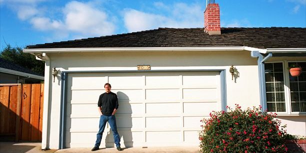 Steve Jobs en 1996 qui prend la pose devant la porte de son garage