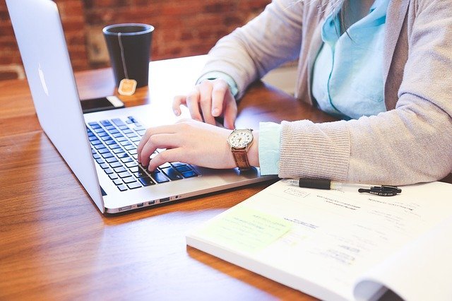 Mains d'une personne qui travaille sur un ordinateur portable